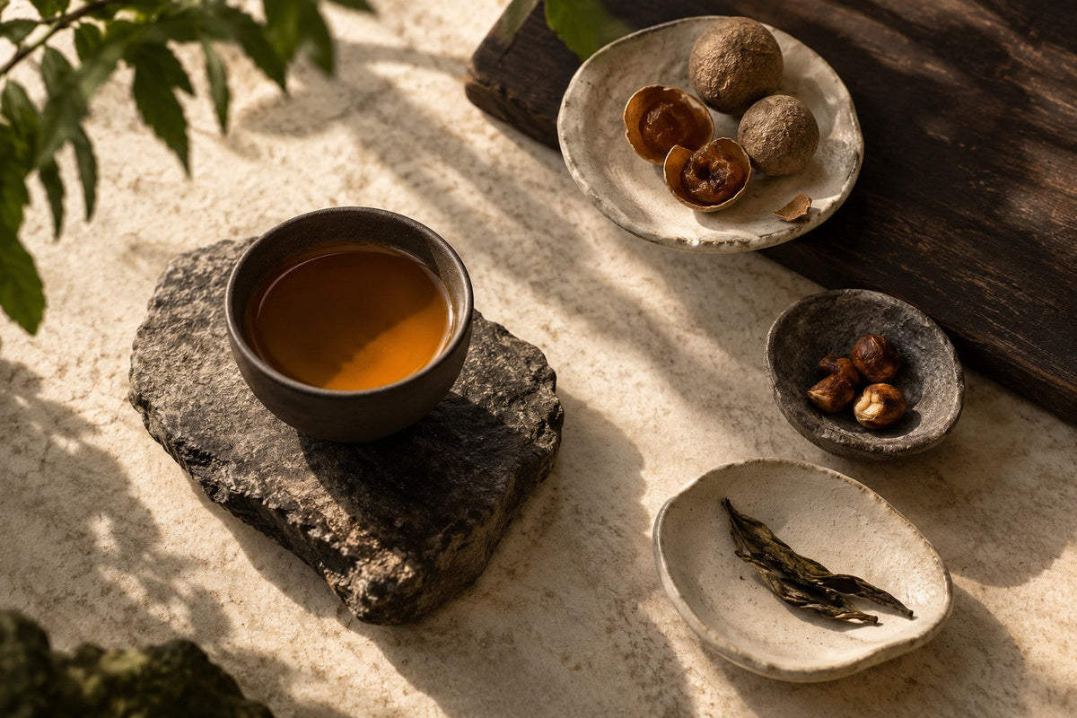 Chá com pratos separados de longan seco, frutos de casca rija e folhas
