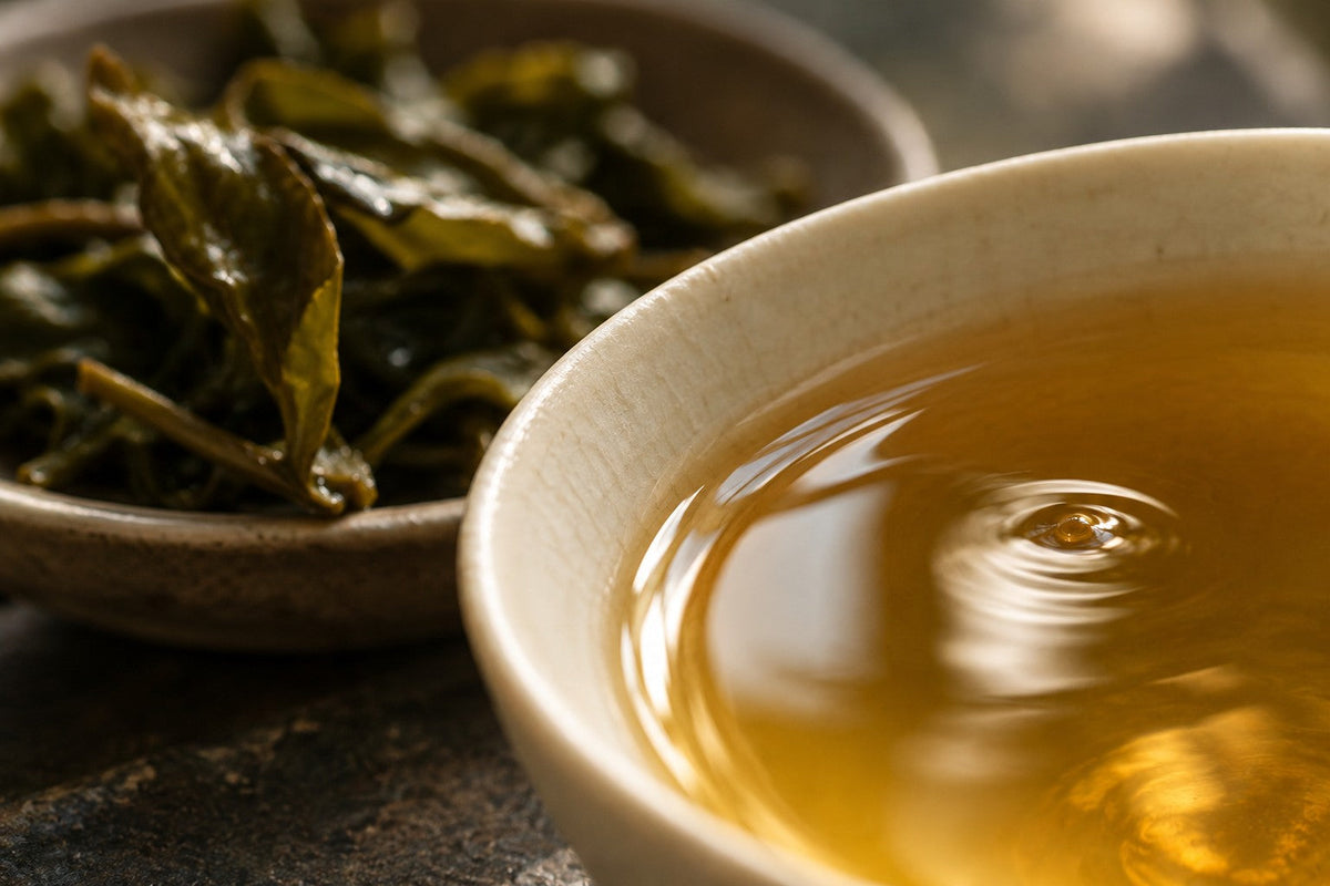 Macro view of a ripple in golden tea beside unfurled leaves