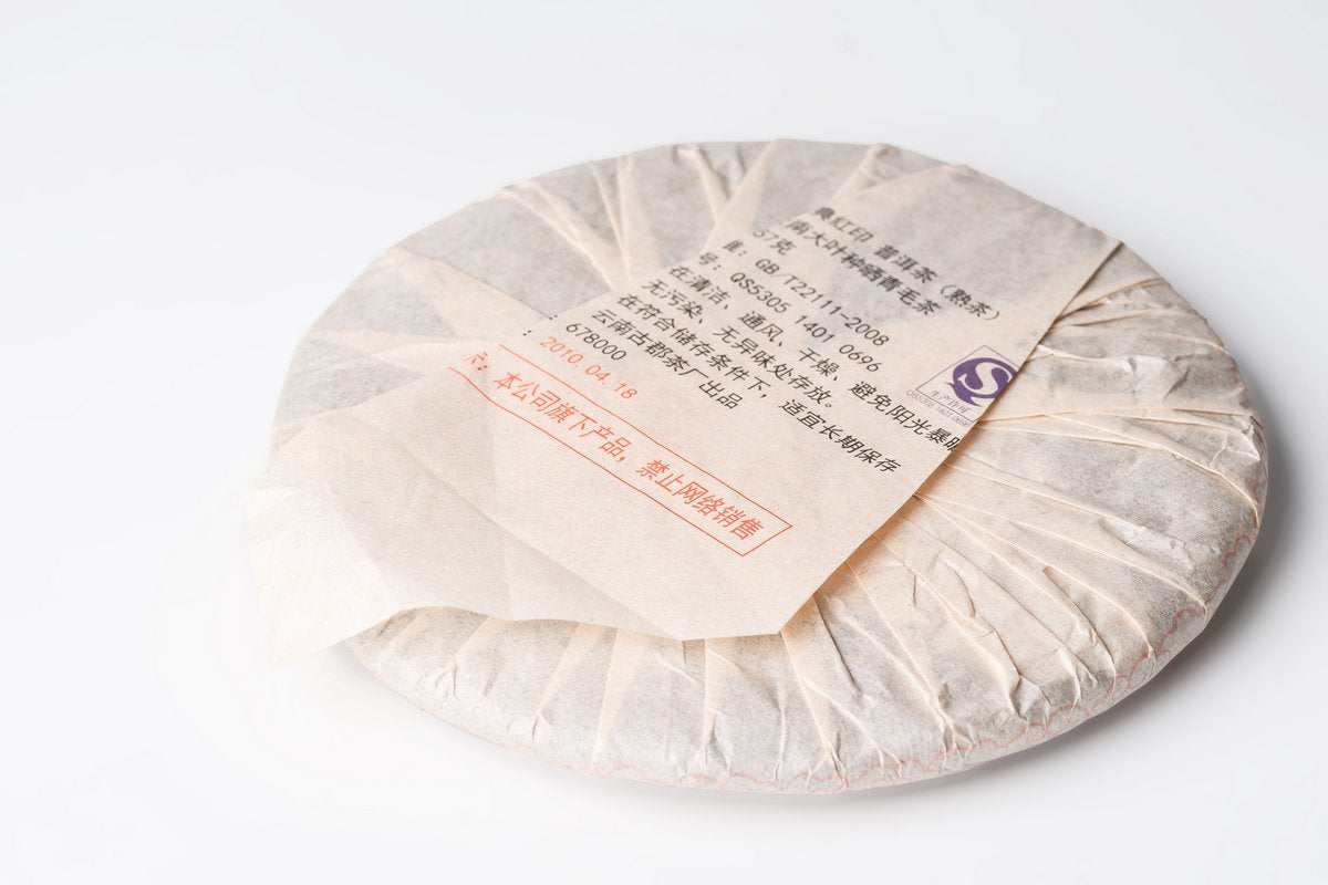 Back of the paper wrapper on a Gui Zhu Red Seal tea cake