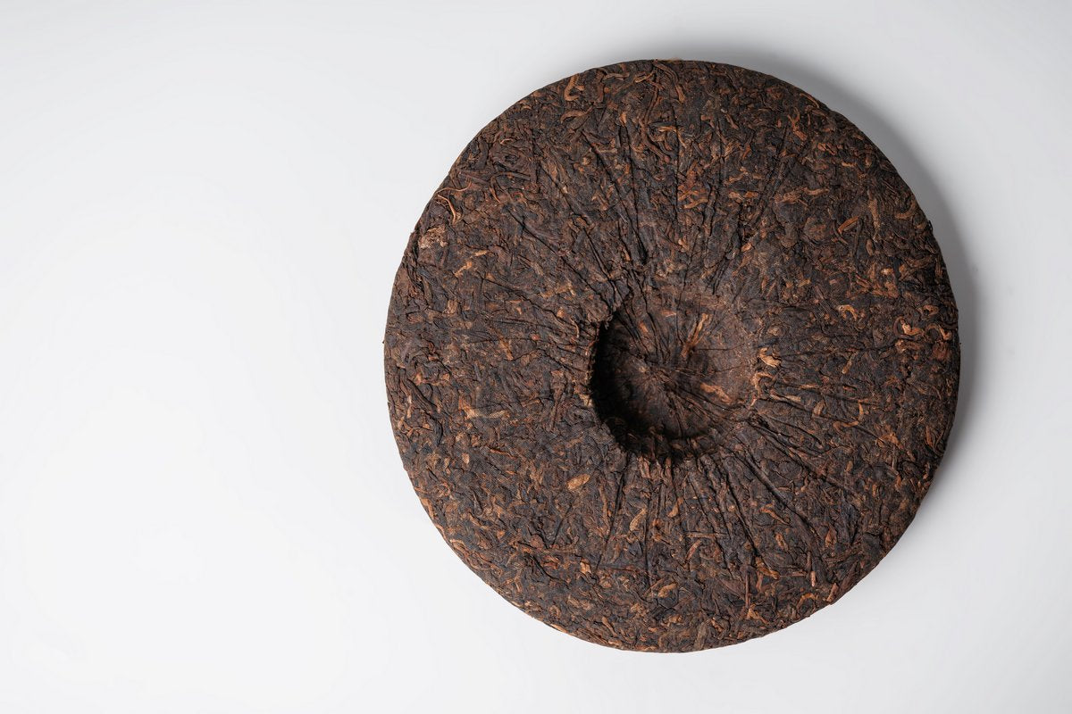 Front view of an unwrapped Gui Zhu Red Seal tea cake