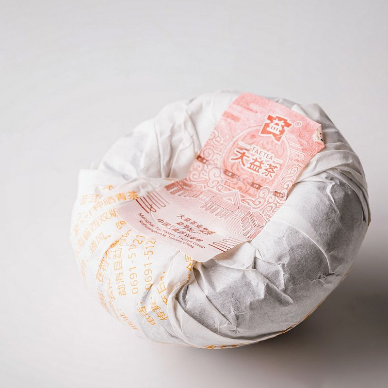 Menghai Dayi V93 tuocha in its paper wrapper, viewed from below